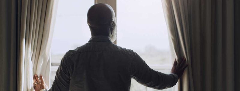 A man gazes thoughtfully out of a window