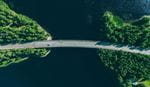 Bridge over water with surrounding greenery, aerial view