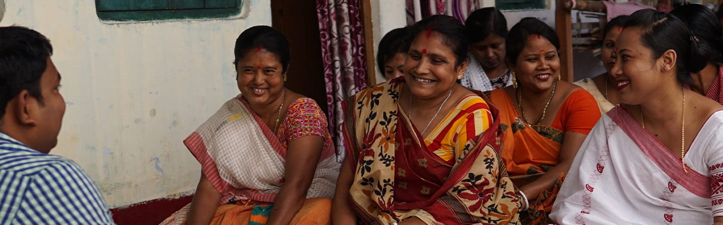 A group of women smiling while sitting on a floor