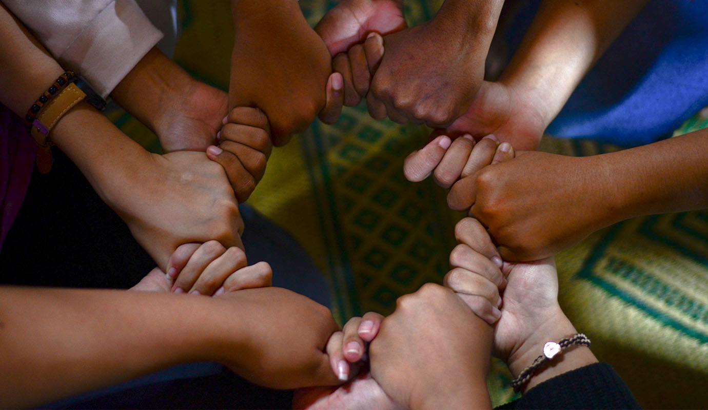 A circle of hands holding