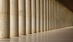 A row of tall, fluted marble columns stretches into the distance, creating a sense of depth. 